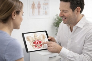 רופא מסביר למטופלת באמצעות טאבלט את מבנה שרירי רצפת האגן